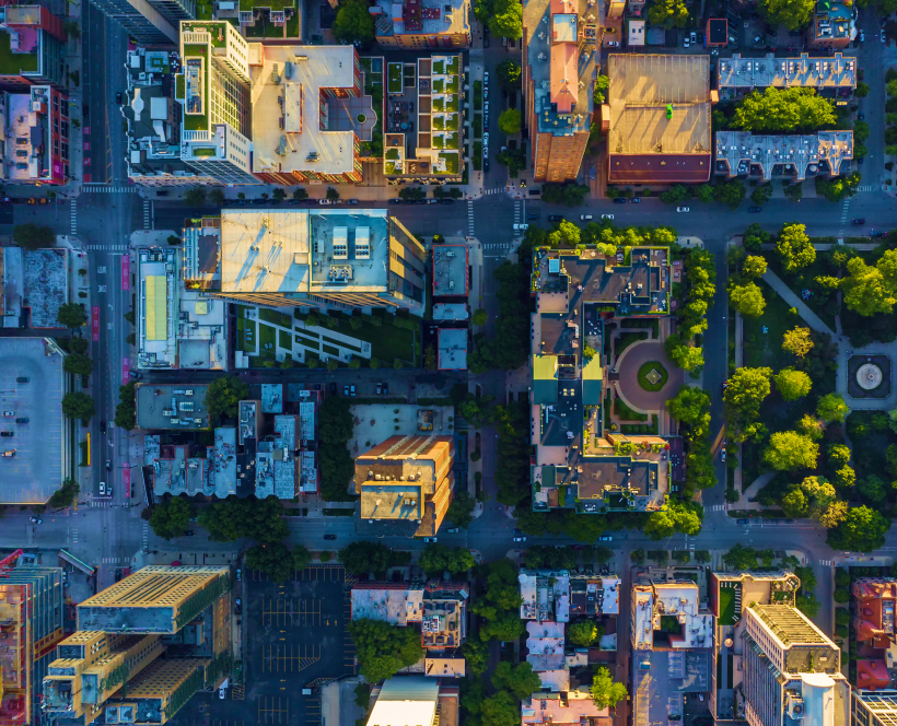 Aerial view of a vibrant downtown cityscape with clustered buildings and illuminated high-rise buildings