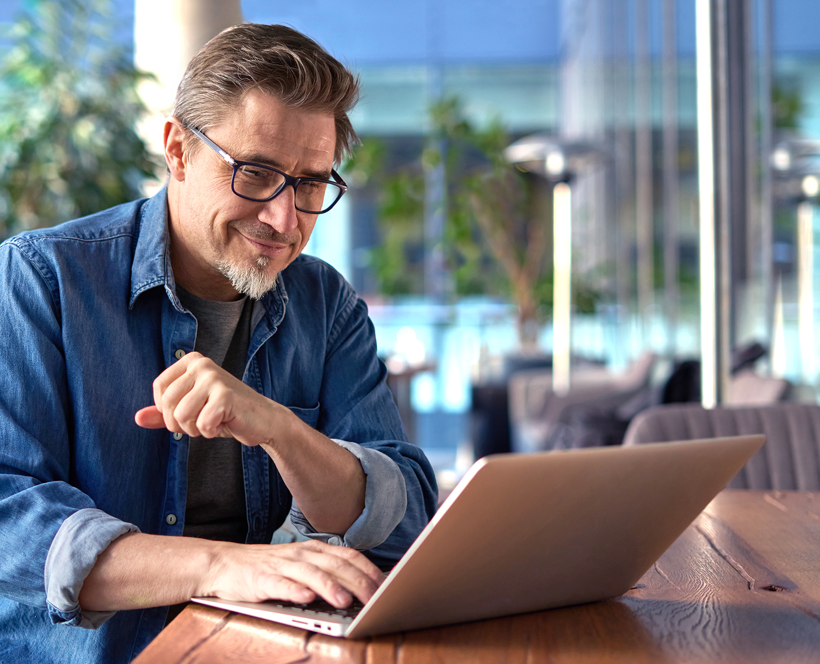 A smiling man working on a laptop